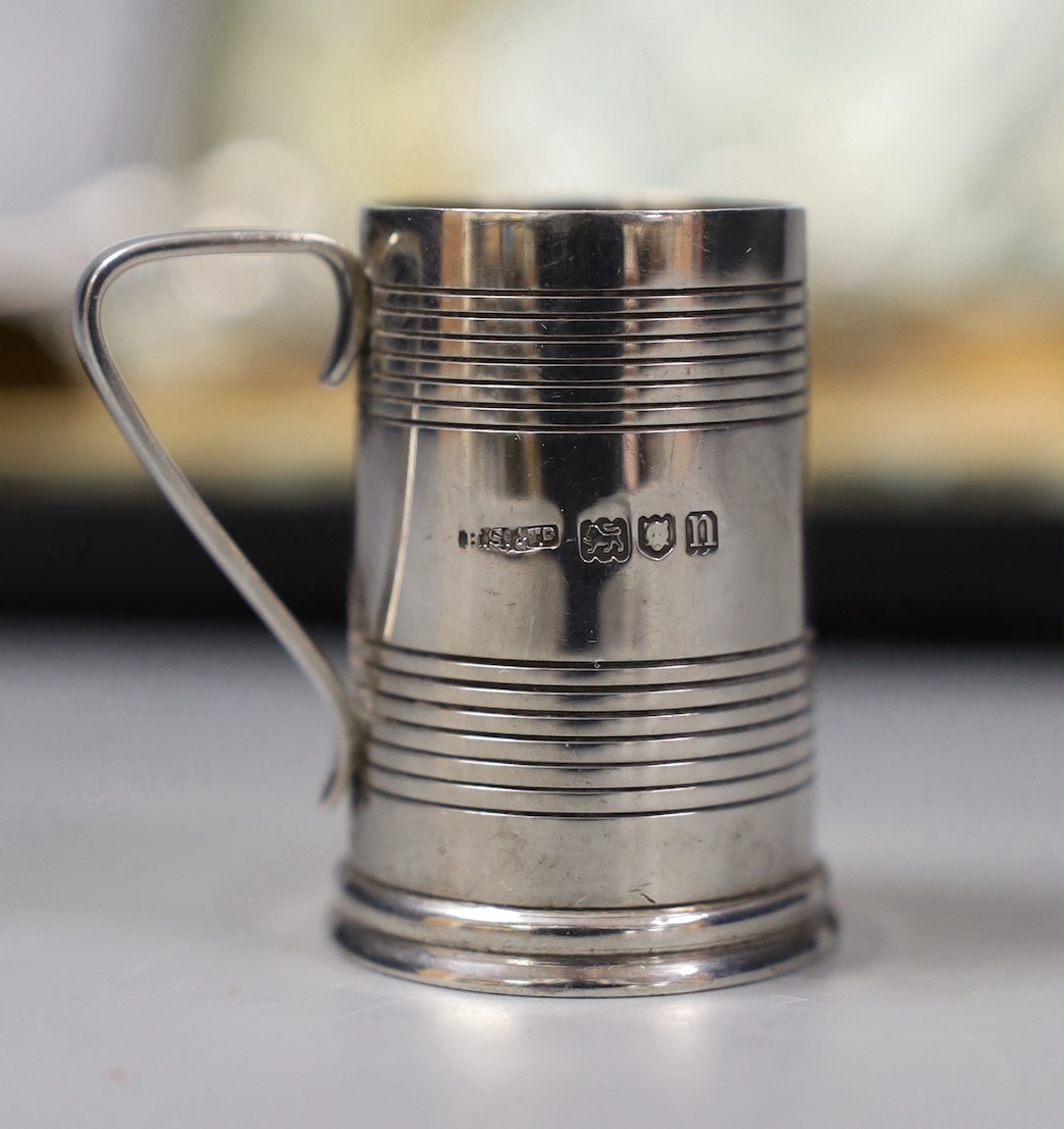 A cased set of six Edwardian reeded silver tot mugs, Harrods Stores Ltd?, London, 1908, 44mm.